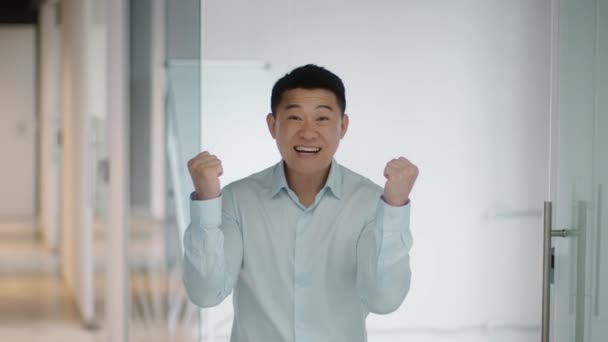 Zorgeloze middelbare leeftijd aziatische werknemer lachen en schreeuwen gelukkig op kantoor, vieren van persoonlijk succes en promotie, slow motion, vrije ruimte - Video