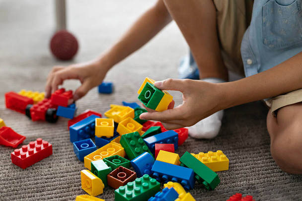 Mały chłopiec maluch bawi się kolorowe plastikowe klocki w domu salon na dywanie budynku twórczej gry, wyobraźni. TURKEY. ISTANBUL - czerwiec 2022 r. - Zdjęcie, obraz