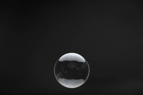 Flying soap bubbles on black background. Abstract soap bubbles with reflections. Soap bubbles in motion background. - Photo, image