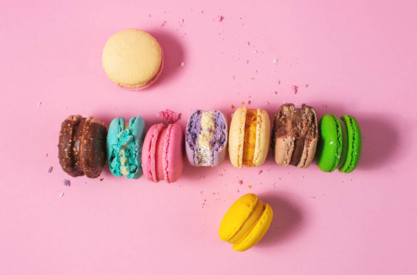 Яскраві барвисті різні смакові макарони солодке печиво на рожевому фоні. Вид зверху
 - Фото, зображення