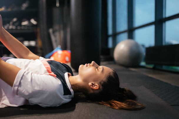 Young woman doing exercises in the gym during morning - Foto, afbeelding
