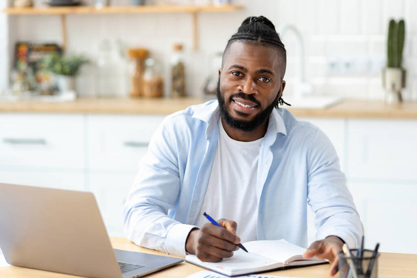 Distance learning, online education. Portrait of smiling African American adult male freelancer working remotely from home, looking at camera, smiling - Zdjęcie, obraz