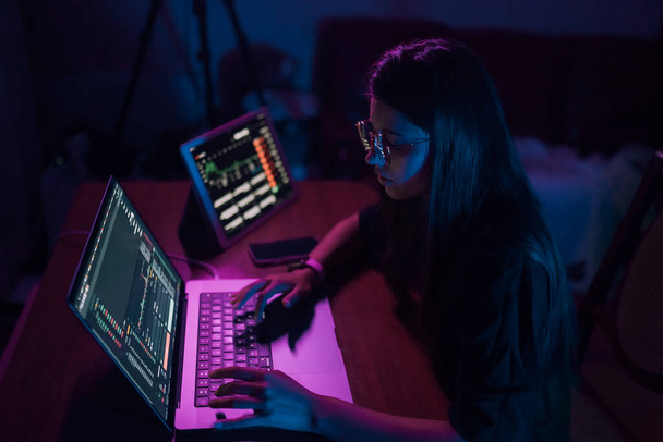 Atrakcyjna młoda kobieta pracująca w domu w nocy. Dziewczyna korzystająca z laptopa. - Zdjęcie, obraz