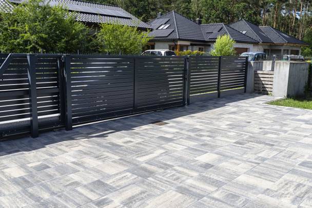Modern panel fencing in anthracite color, visible sliding gate to the garage as well as a handle and a lock - Foto, Bild