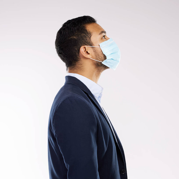 All we can do is have hope for a better tomorrow. Studio shot of a young businessman wearing a face mask against a white background - Foto, immagini