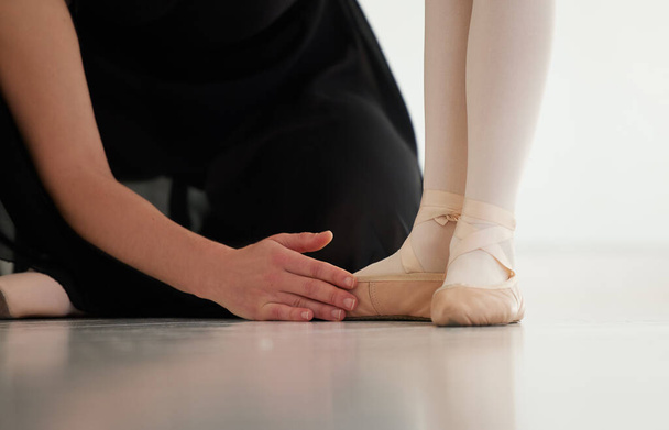 Correctly her stance and position. Closeup shot of a ballet teacher assisting a student with her position in a dance studio - Fotografie, Obrázek