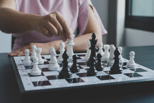Hand of businesswoman moving, chess in competition shows leadership, followers, and business success strategies. - Foto, Imagem