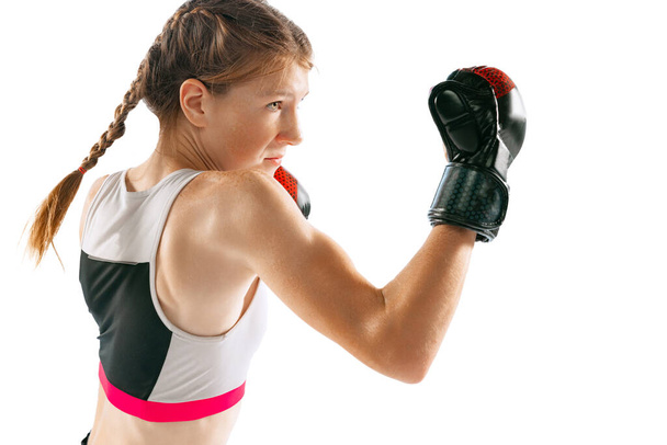 Champion, combat sport. Female junior MMA fighter in sports uniform training isolated on white background. Concept of sport, competition, action, health. Copy space for ad. - Фото, изображение