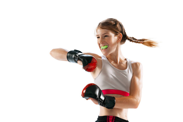 Champion, combat sport. Female junior MMA fighter in sports uniform training isolated on white background. Concept of sport, competition, action, health. Copy space for ad. - Photo, Image