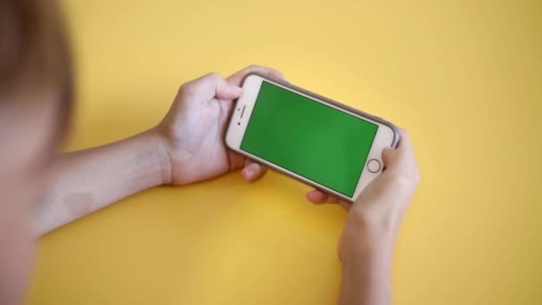 Child Using Phone With Green Mock-up. Surfing Internet Watching Content Videos Blogs Learning. boy Playing Video Games. chroma key for copy space. Slow motion. - Materiał filmowy, wideo