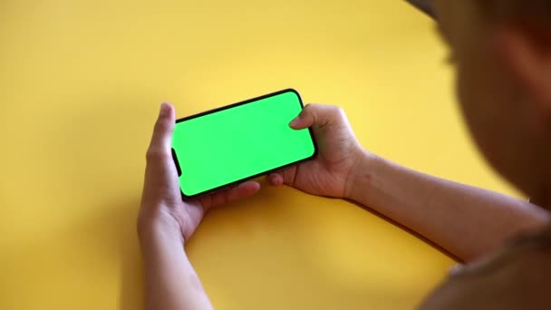 Child Using Phone With Green Mock-up. Surfing Internet Watching Content Videos Blogs Learning. boy Playing Video Games. chroma key for copy space. Slow motion. - Filmagem, Vídeo