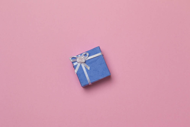 A small purple gift box isolated in the pink background - Fotografie, Obrázek