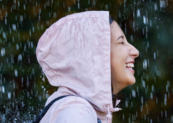 De regen geeft me het gevoel dat ik leef. een aantrekkelijke jonge vrouw staat alleen buiten in de regen - Foto, afbeelding