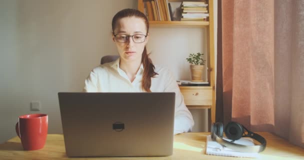 Vrouw werkt op de computer thuis kantoor, drinkt koffie, thee. Werkproces zakenvrouw in functie. Versnelde tijdsperiode, snelheid, vooraanzicht. Hoge kwaliteit 4k beeldmateriaal - Video