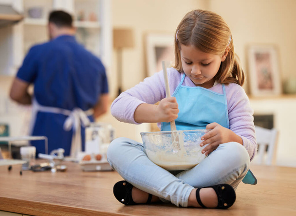 Dad says these are going to be amazing. a little girl stirring a bowl of batter - Foto, Imagem