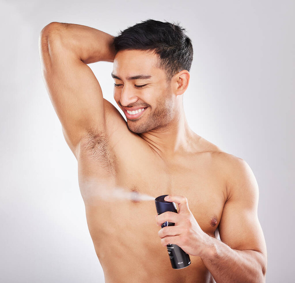 Preparation is confidence. Studio shot of a handsome young man applying deodorant - Photo, Image