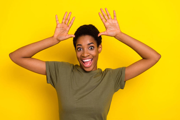 Portrait of excited positive person arms make ears good mood isolated on yellow color background. - Foto, Imagen