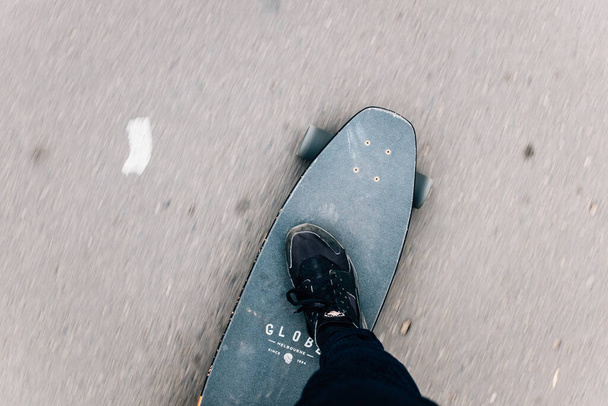 A closeup shot of human feet riding a skateboard - Фото, изображение