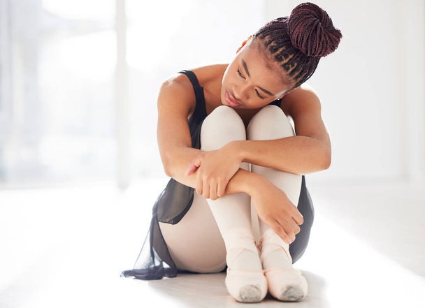 It takes time and dedication to be good at anything. a ballerina looking sad while sitting in her dance studio - Photo, image