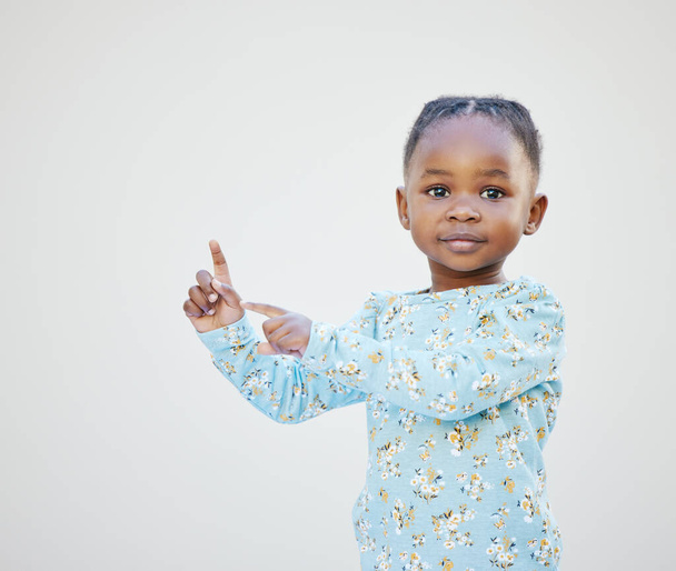 Think Im cute Check this out. an adorable little girl standing against a white background - Photo, image