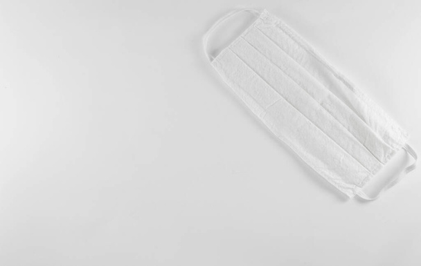 Біла медична одноразова протиотруйна маска для захисту від вірусу Ковід-19 Корона. Маска з одноразовим фільтром обличчя на білому тлі, концепція захисту, простір копіювання. - Фото, зображення