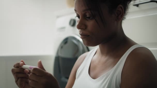 Lähikuva Afrikkalainen-amerikkalainen stressaantunut nainen odottaa raskaustestituloksia. Laukaus punaisella heliumkameralla 8K.     - Materiaali, video