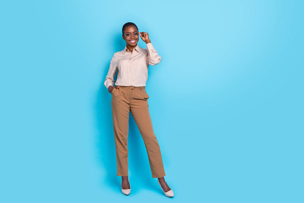 Full size photo of cheerful intelligent young businesswoman wear fashionable clothes isolated on blue color background. - 写真・画像