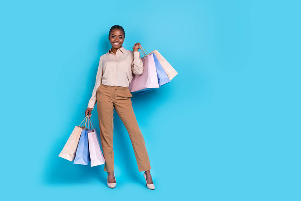 Full length image of young stunning business lady go shopping on black friday sales isolated on blue color background. - Fotografie, Obrázek