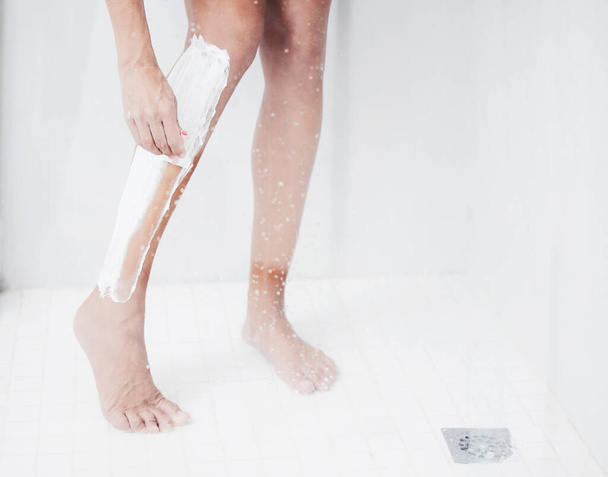 The smoothest legs youve ever felt. a woman shaving her legs in the shower - Foto, immagini