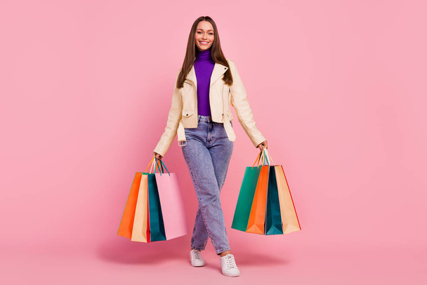 Full size photo of fashion cool young lady go shopping hold bags wear casual cloth shoes isolated on pastel pink color background. - 写真・画像