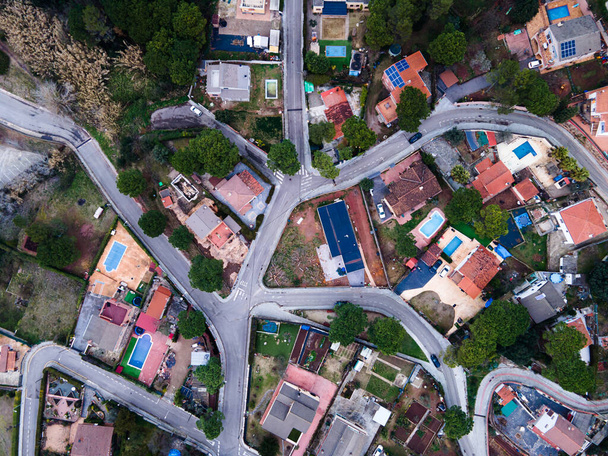 A top view of a city with cars traveling on roads and buildings during the daytime - Fotoğraf, Görsel
