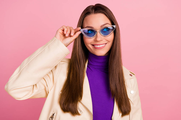 Fénykép a szép fiatal hölgy kezek szemüveg megjelenés hirdetés kopás kabát lila garbó elszigetelt rózsaszín szín háttér. - Fotó, kép