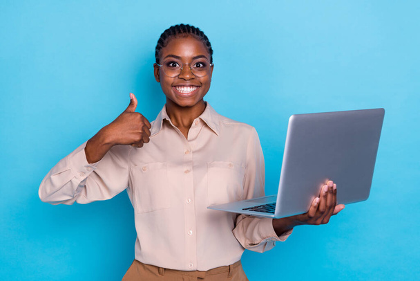 Photo of cheerful businesswoman recommend rate laptop gadget show thumb-up isolated on blue color background. - Fotoğraf, Görsel