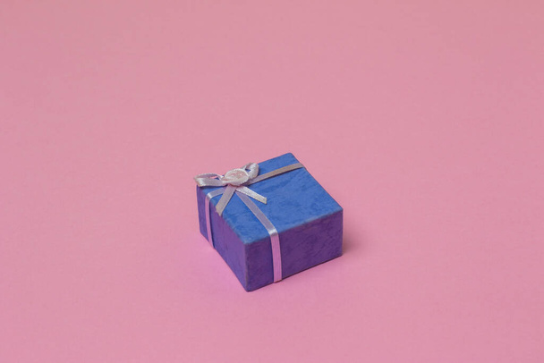 A purple gift box isolated on the pink surface - Φωτογραφία, εικόνα