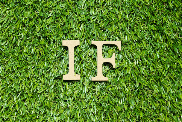 Litera alfabetu drewna w słowie, jeśli na zielonym tle trawy - Zdjęcie, obraz