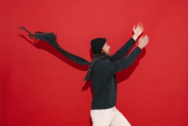 White man in warm clothes screaming with hands up isolated over red background - Fotó, kép