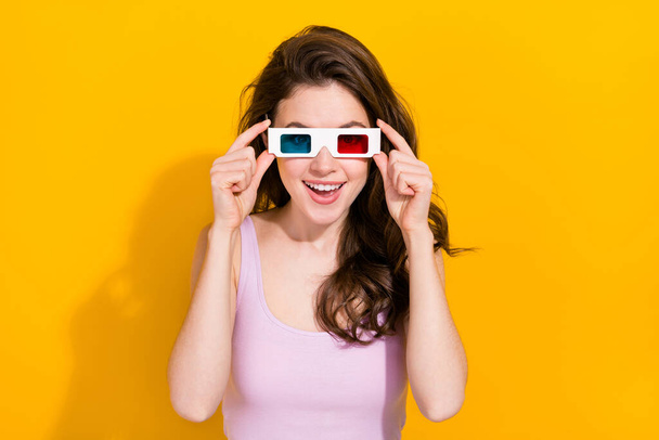 Photo of positive pretty girl hands touch 3d glasses enjoy good mood isolated on yellow color background. - 写真・画像
