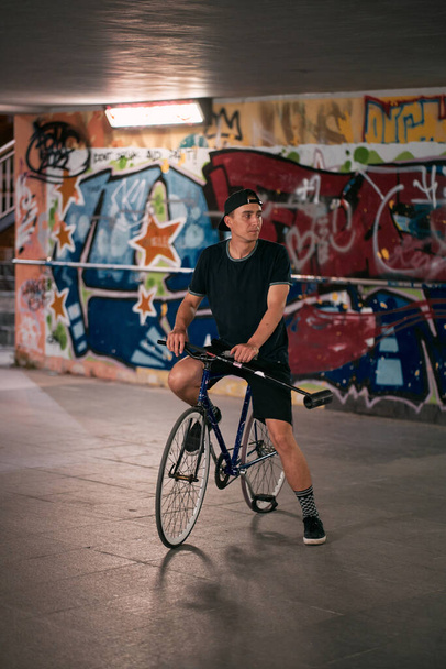 28.07.2022 Poland, Tri-city, Gdansk - Young guys are playing Bike Polo on asphalt in the underground crossing near Ergo Arena. - 写真・画像