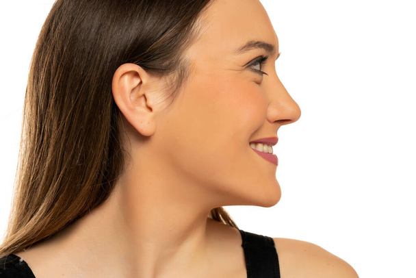Profile of a young beautiful happy woman with makeup on a white background - Zdjęcie, obraz