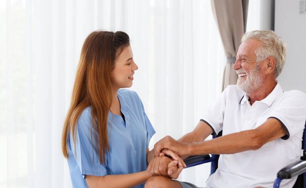 female doctor helping care holding hands to encourage talk Caucasian older man, older adult, patient in a wheelchair at nursing ward health concept Help restore aging, medical and retirement. - Fotografie, Obrázek