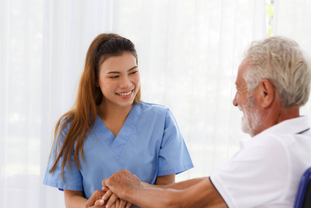 female doctor helping care holding hands to encourage talk Caucasian older man, older adult, patient in a wheelchair at nursing ward health concept Help restore aging, medical and retirement. - Foto, Bild