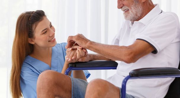 female doctor helping care holding hands to encourage talk Caucasian older man, older adult, patient in a wheelchair at nursing ward health concept Help restore aging, medical and retirement. - Fotó, kép