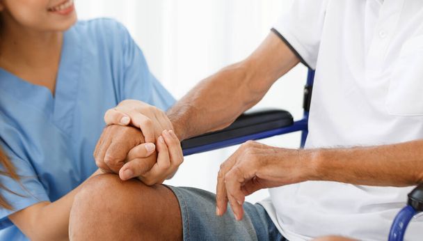 close up Female doctor holding a male Caucasian senior's hand patient in a wheelchair Encouragement, talking, helping to take care of the elderly, concepts, health, rehabilitation, medical, retirement - Foto, Bild
