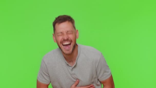 Bearded young man laughing out loud after hearing ridiculous anecdote, funny joke, feeling carefree amused, positive people lifestyle. Adult guy isolated on green chroma key studio background indoors - Filmati, video