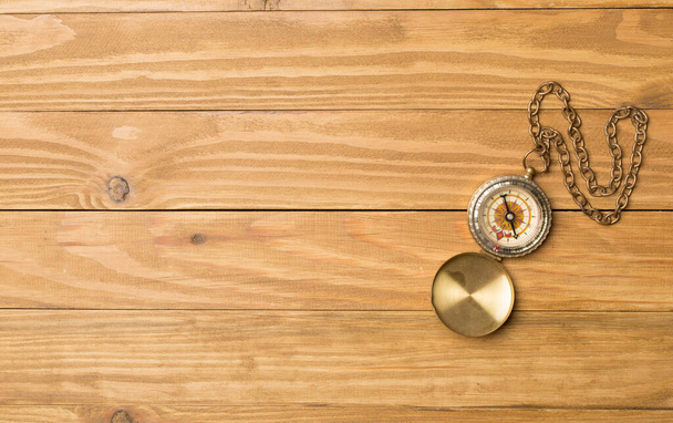 Old vintage compass on wooden background. Top view. - Фото, изображение