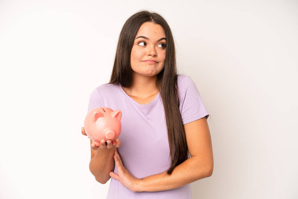 hispanic pretty woma looking desperate, frustrated and stressed. piggy bank savings concept - Фото, изображение