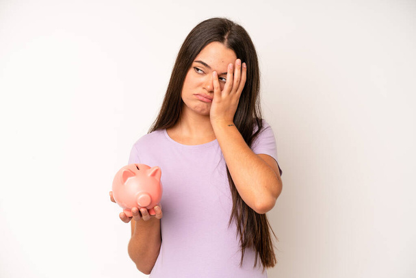 hispanic pretty woma looking very shocked or surprised. piggy bank savings concept - Fotoğraf, Görsel