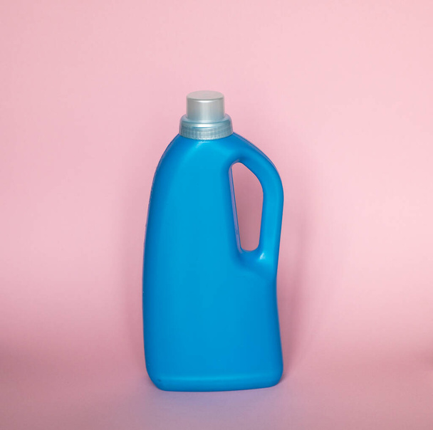Blue plastic bottle with a grey cap isolated on pink background for liquid detergent laundry or cleaning agent. Packaging template mockup - Fotó, kép