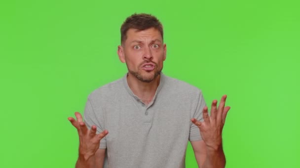 Quarrel. Displeased handsome young man gesturing hands with irritation and displeasure, blaming scolding for failure asking why this happened. Adult guy isolated on chroma key studio background indoor - Séquence, vidéo