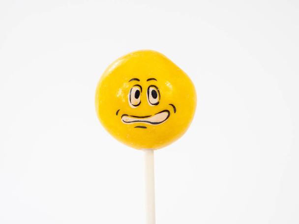 Yellow lollipops. Lollipops with a painted face. Lollipops close-up. - Photo, Image
